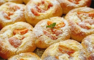 Saftige Hefekuchen mit Vanillepudding, Aprikosen und Rum-Butter Blech voller goldgelber, runder Hefekuchen mit Pudding, leuchtend orangefarbenen Aprikosen und knusprigen Streuseln, glänzend bestrichene Ränder.
