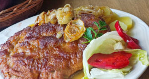 Saftige umgedrehte Schweineschnitzel im Ofen auf Speck und Zwiebeln gebacken Saftige umgedrehte Schweineschnitzel auf Speck und Zwiebeln gebacken