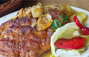 Saftige umgedrehte Schweineschnitzel im Ofen auf Speck und Zwiebeln gebacken Saftige umgedrehte Schweineschnitzel auf Speck und Zwiebeln gebacken