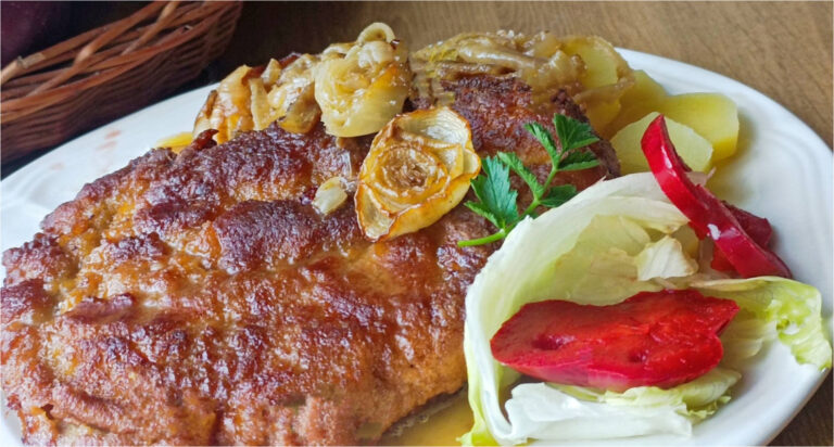 Saftige umgedrehte Schweineschnitzel im Ofen auf Speck und Zwiebeln gebacken