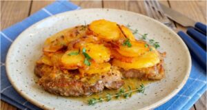 Saftiger Schweinenacken überbacken mit Sahnekartoffeln und karamellisierten Zwiebeln Schweinenacken aus einer Auflaufform mit Sahnekartoffeln und Curry-Zwiebeln