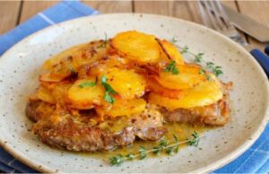 Saftiger Schweinenacken überbacken mit Sahnekartoffeln und karamellisierten Zwiebeln Schweinenacken aus einer Auflaufform mit Sahnekartoffeln und Curry-Zwiebeln