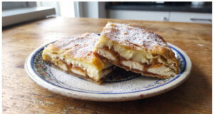 Apfel-Pudding-Schnitten aus Blätterteig: Saftiges Dessert mit einfacher Schichtung Apfel-Pudding-Schnitten aus Blätterteig aufgeschnitten auf einem Blech