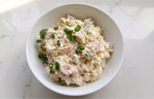 Camembert-Salat mit Schinken und Ei: Schneller cremiger Genuss zu frischem Brot Cremiger Camembert-Salat mit Schinken und Ei serviert in einer Schale