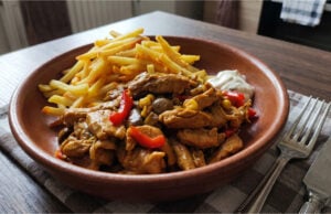 Blitzschnelle Fleischpfanne mit Curry und Gemüse: Saftiges One-Pot-Abendessen Blitzschnelle Fleischpfanne mit Curry und Gemüse serviert in einer Schale