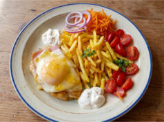 Hähnchenbrust mit Schinken, Käse und Pfirsich: Retro-Mittagessen mit Pommes Hähnchenbrust mit Schinken, Käse und Pfirsich auf einem Teller mit Pommes