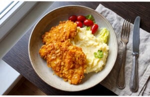 Hähnchenschnitzel in Cornflakes: Knusprige Panade und saftiges Fleisch mit cremigem Püree Hähnchenschnitzel in knuspriger Cornflakes-Panade mit Kartoffelpüree