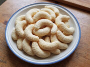 Kokoskipferl: Einfaches Weihnachtsgebäck mit feinem Geschmack und goldener Oberfläche Frisch gebackene Kokoskipferl auf einem Backblech