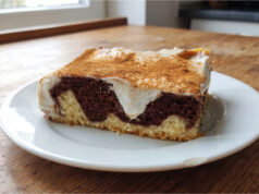 Kuchen mit Pudding und Sauerrahm: Saftiges Gebäck mit Zimtschicht Kuchen mit Pudding und Sauerrahm aufgeschnitten auf einem Blech