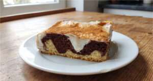 Kuchen mit Pudding und Sauerrahm: Saftiges Gebäck mit Zimtschicht Kuchen mit Pudding und Sauerrahm aufgeschnitten auf einem Blech