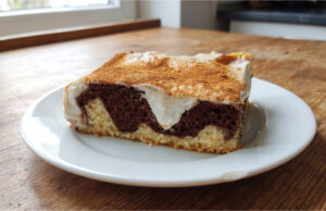 Kuchen mit Pudding und Sauerrahm: Saftiges Gebäck mit Zimtschicht Kuchen mit Pudding und Sauerrahm aufgeschnitten auf einem Blech