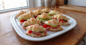 Herzhafte Mini-Croissants aus Blätterteig: Schnelles Fingerfood mit Füllung nach Wahl Verschiedene herzhafte Mini-Croissants aus Blätterteig auf einer Servierplatte