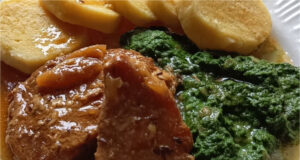 Perfektes Mittagessen: Saftiges geschmortes Schweinekotelett in Schmalz, hausgemachter Spinat und echte Kartoffelknödel Saftiges geschmortes Schweinekotelett mit Spinat und Kartoffelknödeln