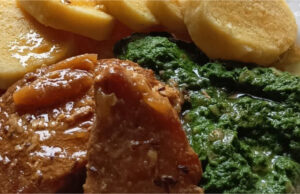 Perfektes Mittagessen: Saftiges geschmortes Schweinekotelett in Schmalz, hausgemachter Spinat und echte Kartoffelknödel Saftiges geschmortes Schweinekotelett mit Spinat und Kartoffelknödeln