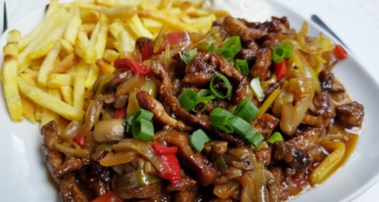 Schweinefleischstreifen aus einer Pfanne: Saftiges Fleisch mit Gemüse, Champignons und knusprigen Pommes