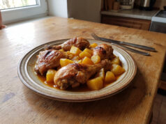 Überbackene Hähnchenschenkel mit Kartoffeln und Sauce: Einfaches Blechgericht Überbackene Hähnchenschenkel mit Kartoffeln und Sauce auf einem Blech