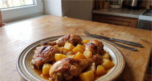 Überbackene Hähnchenschenkel mit Kartoffeln und Sauce: Einfaches Blechgericht Überbackene Hähnchenschenkel mit Kartoffeln und Sauce auf einem Blech