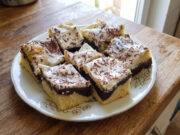 Zickzack-Kuchen mit Pudding und Sauerrahm: Saftiges Dessert mit einfacher Dekoration Zickzack-Kuchen mit Pudding und Sauerrahm aufgeschnitten auf einem Blech