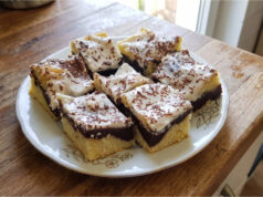 Zickzack-Kuchen mit Pudding und Sauerrahm: Saftiges Dessert mit einfacher Dekoration Zickzack-Kuchen mit Pudding und Sauerrahm aufgeschnitten auf einem Blech