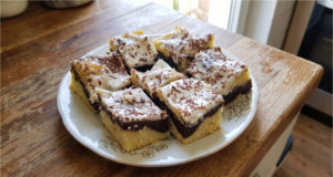 Zickzack-Kuchen mit Pudding und Sauerrahm: Saftiges Dessert mit einfacher Dekoration Zickzack-Kuchen mit Pudding und Sauerrahm aufgeschnitten auf einem Blech