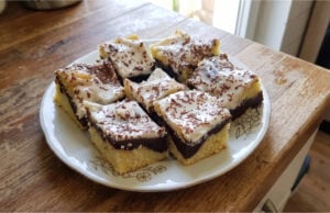 Zickzack-Kuchen mit Pudding und Sauerrahm: Saftiges Dessert mit einfacher Dekoration Zickzack-Kuchen mit Pudding und Sauerrahm aufgeschnitten auf einem Blech