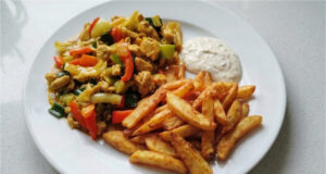 Hähnchen nach chinesischer Art mit hausgemachten Pommes: Saftiges Fleisch, knackiges Gemüse und goldene Beilage Hähnchen nach chinesischer Art mit hausgemachten Pommes, saftiges Fleisch, knackiges Gemüse und goldene Beilage