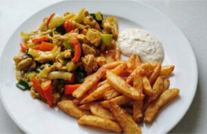 Hähnchen nach chinesischer Art mit hausgemachten Pommes: Saftiges Fleisch, knackiges Gemüse und goldene Beilage Hähnchen nach chinesischer Art mit hausgemachten Pommes, saftiges Fleisch, knackiges Gemüse und goldene Beilage