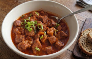 Langsam geschmorter Schweinenacken mit Bier und Honig: Zartes Fleisch mit glänzender Sauce Langsam geschmorter Schweinenacken mit Bier und Honig, serviert mit glänzender Sauce