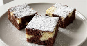 Saftiger Becherkuchen mit Quark: Lockerer Kakaoteig und zarte Cremefüllung Saftiger Becherkuchen mit Quark aufgeschnitten auf einem Blech