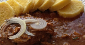 Schweinefleisch mit Paprika und Waldpilzen: Duftendes Mittagessen, gebunden mit geriebener Kartoffel Schweinefleisch mit Paprika und Waldpilzen, serviert mit Kartoffelknödeln
